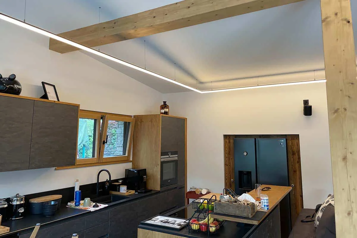 Moderne Küche mit Holzakzenten, LED-Beleuchtung und Elektroinstallation von Elektro Lackner.